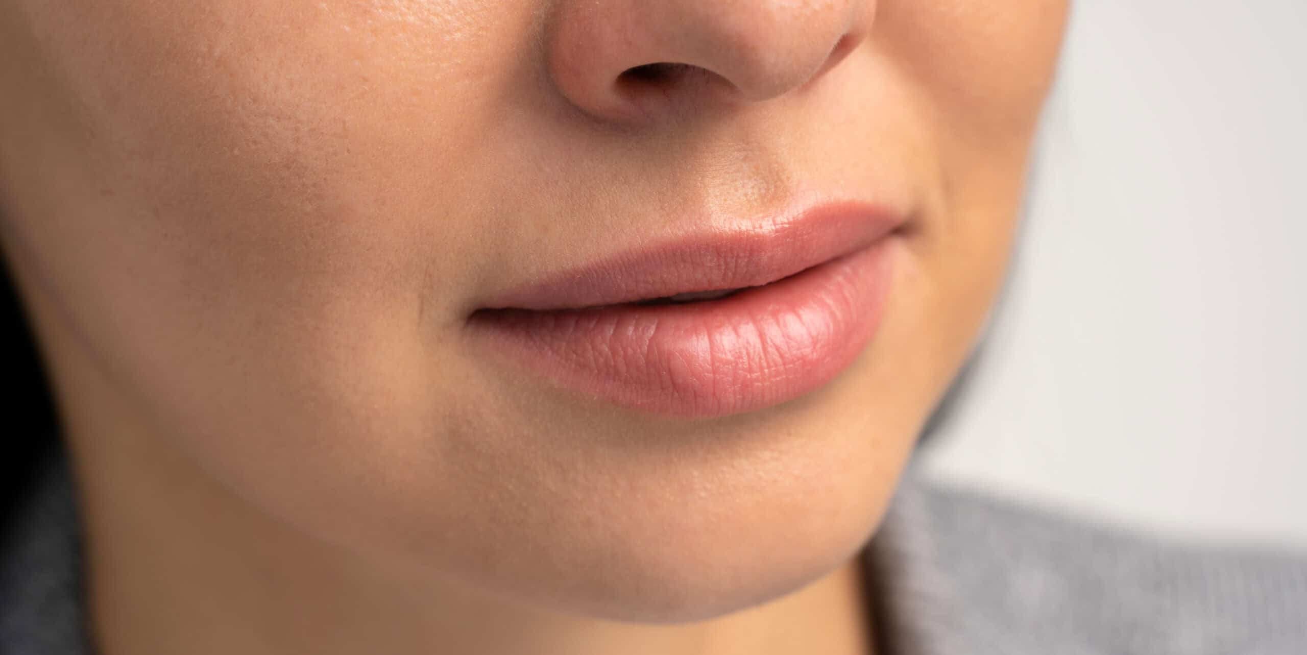 Perfect natural lips. Close-up portrait of young woman with beautiful lips. Macro cropped photo with beautiful attractive female mouth. Wellness, wellbeing, treatment and therapy concept